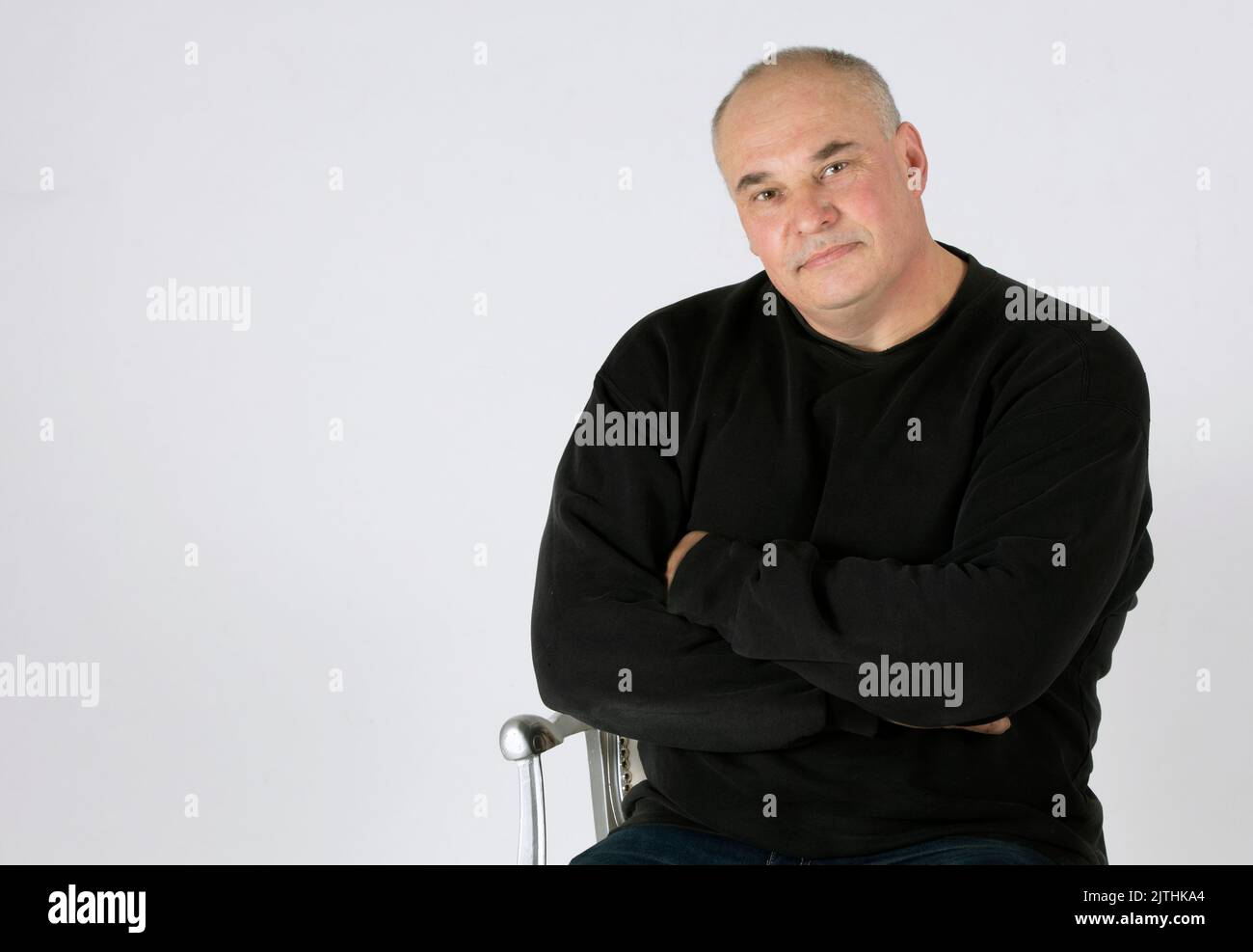 Portrait of a large middle-aged man on a gray background. Stock Photo