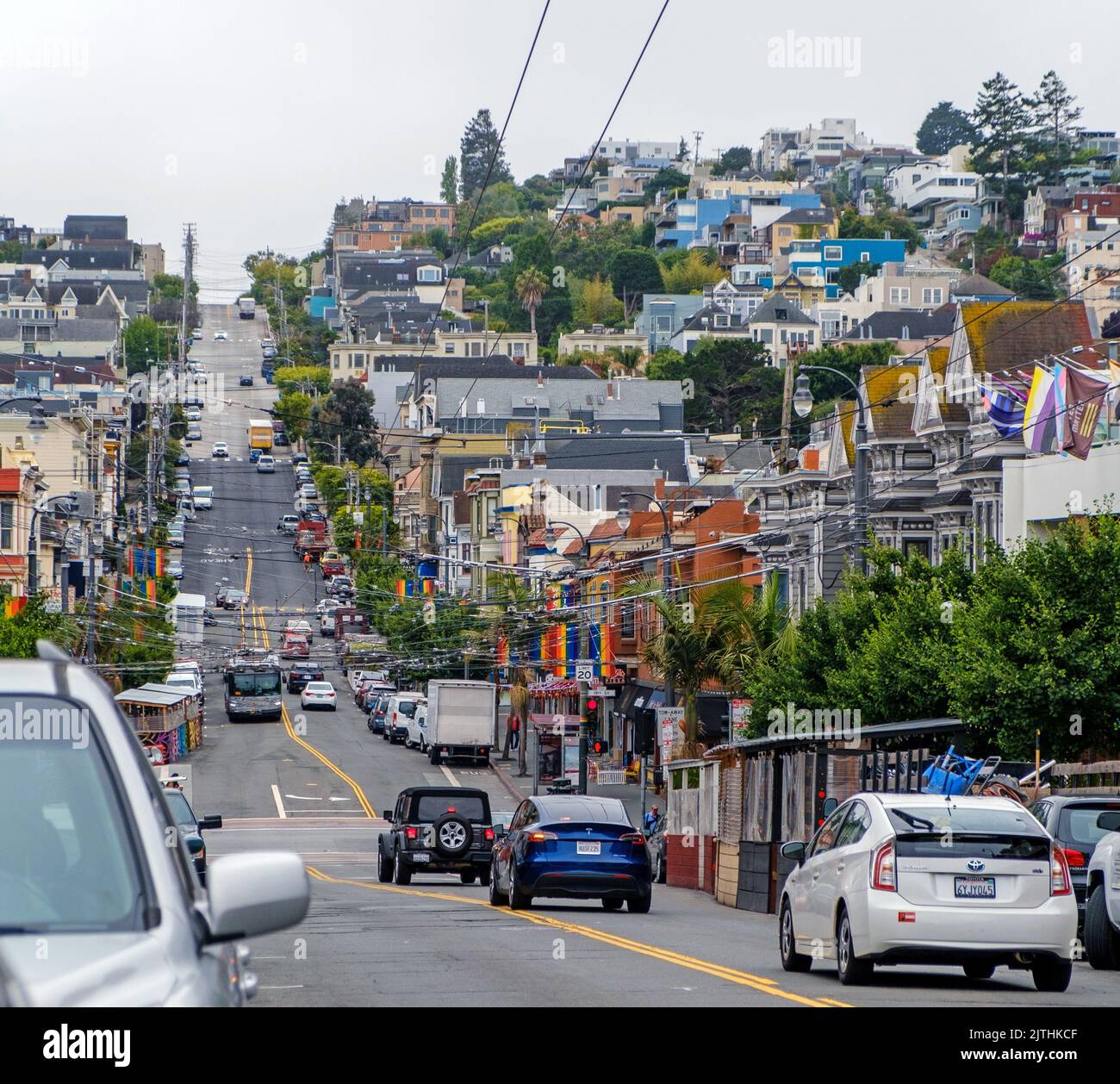 Castro Street, San Francisco, California. Hill with cars, houses, shops and rainbow flags. Stock Photo