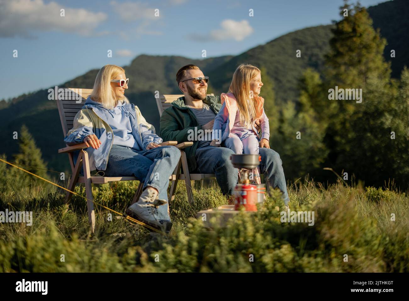 Young family with little girl on picnic in the mountains Stock Photo