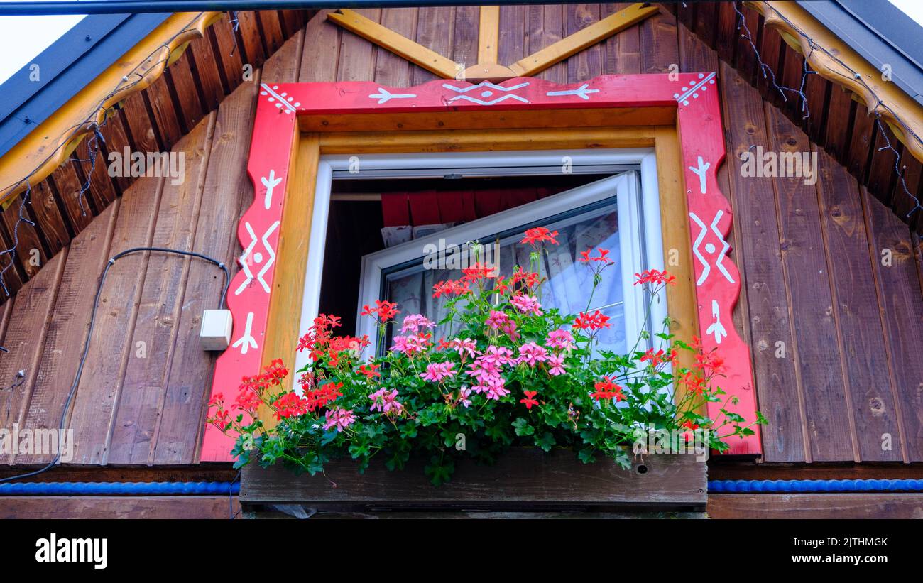 Decorative element of an old wooden house. Red wooden window frame. National symbols of Slovakia. Stock Photo