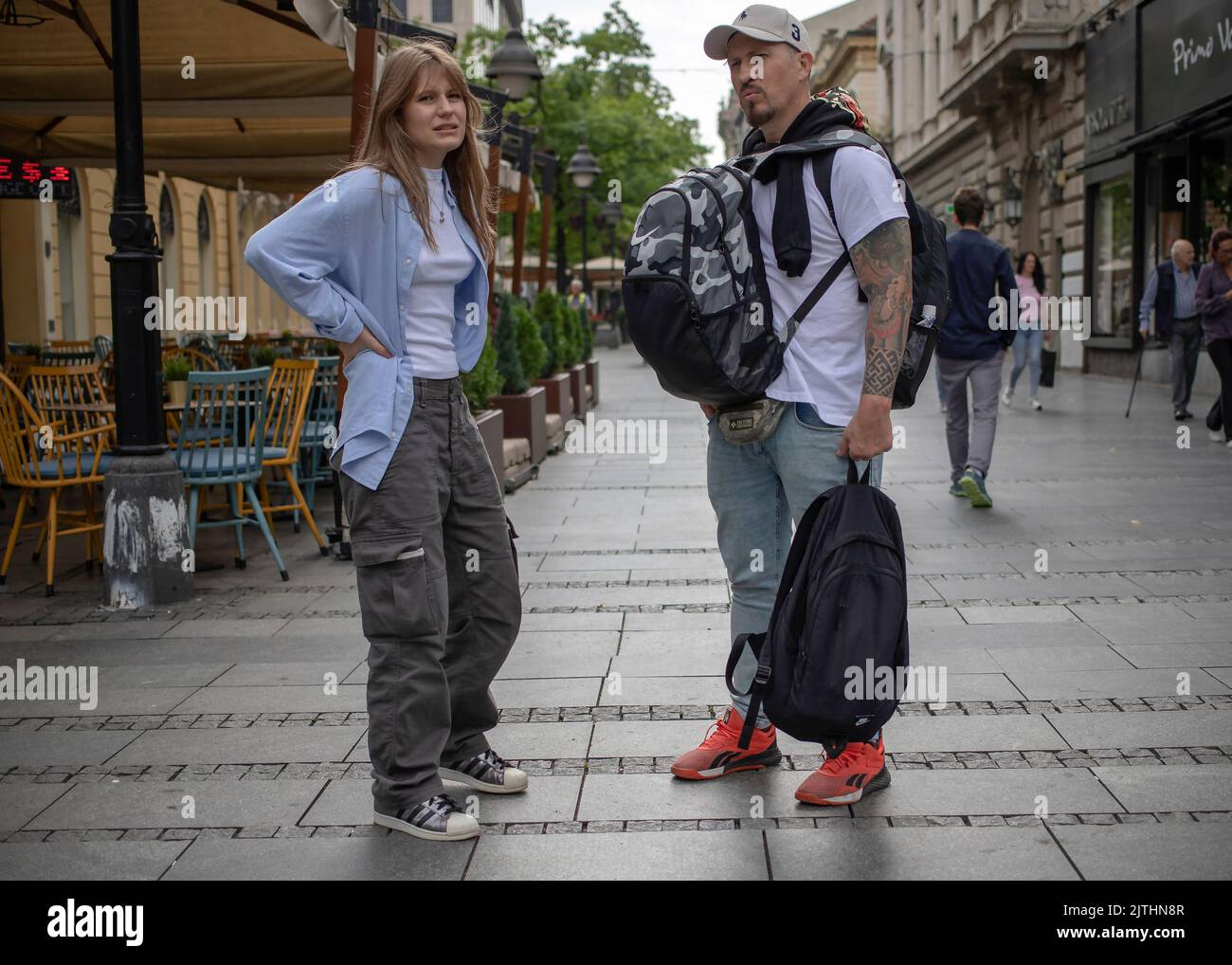 Belgrade, Serbia, Aug 30, 2022: Woman standing on the street next to a tattooed man Stock Photo