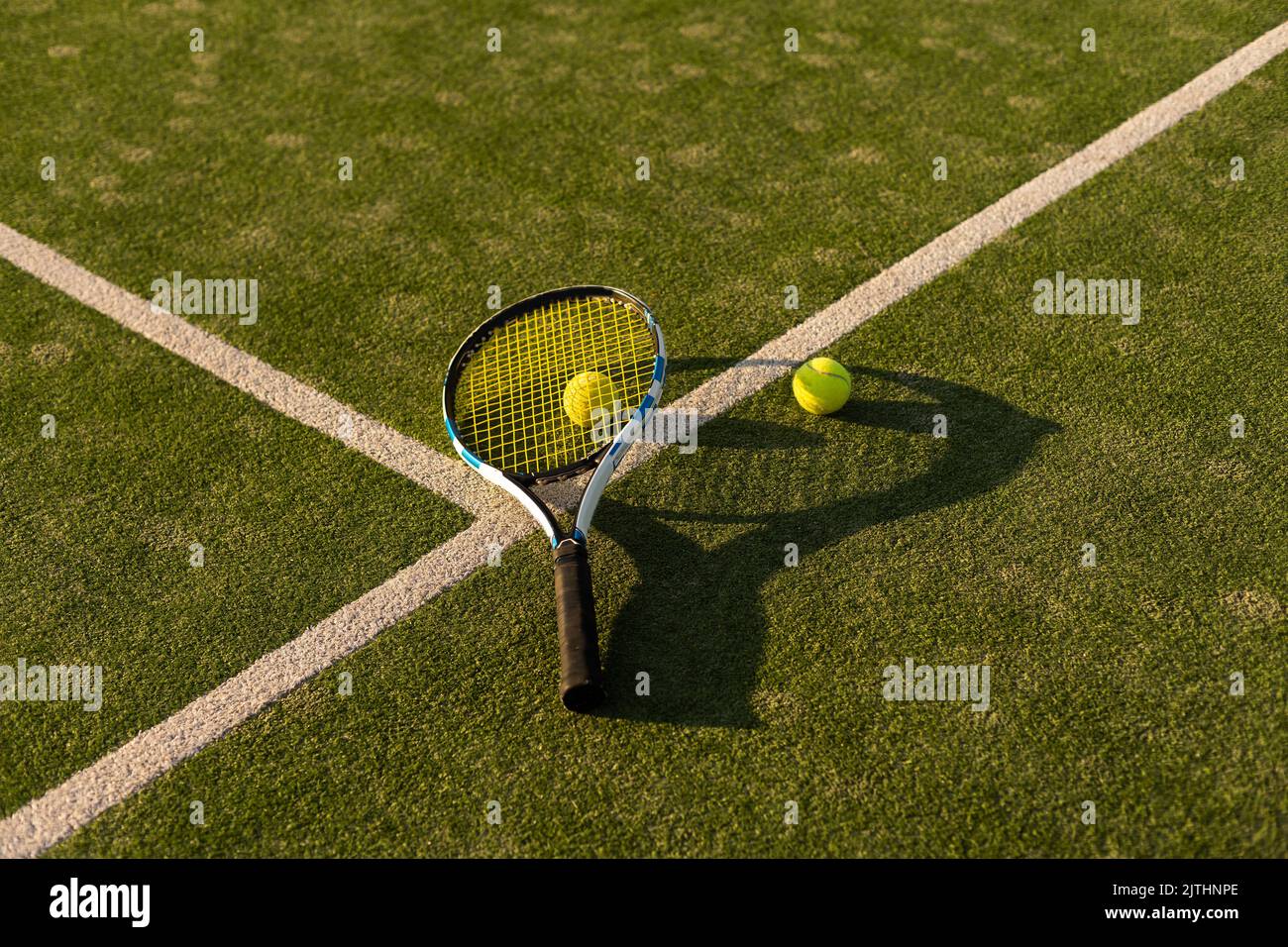 tennis balls and racket on the green grass background Stock Photo - Alamy