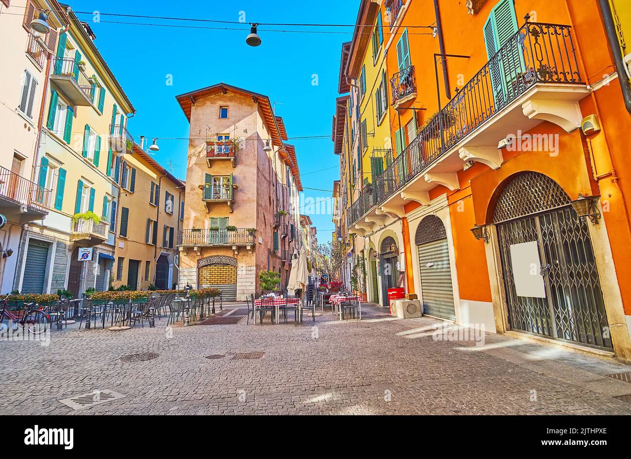 The old narrow Vicolo due Torri street with colored houses, small outdoor cafes, shops and tiny alleys, Brescia, Italy Stock Photo