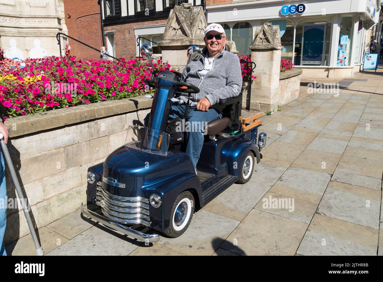 Champion mobility scooter in shape of an American truck with owner, High street Lincoln city 2022 Stock Photo