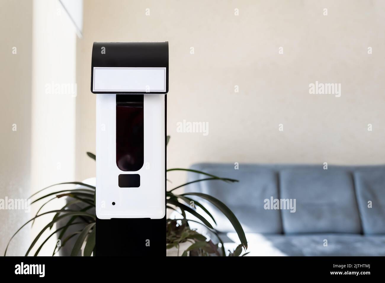 Close-up detail of smart automatic touchless hand sensor sanitizer disinfectant spray dispenser machine device office entrance, hospital or shopping Stock Photo