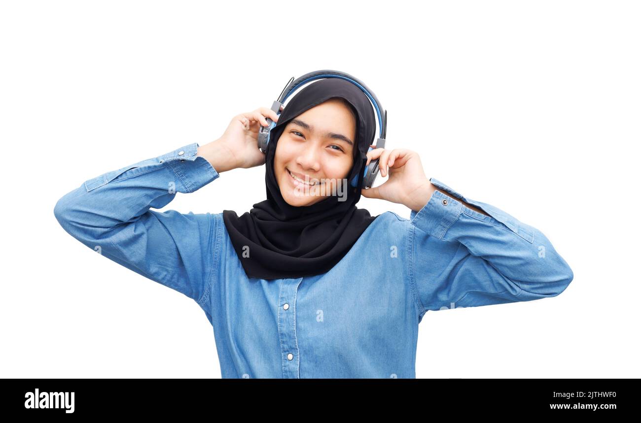 A Muslim girl listened to music with headphones. Stock Photo