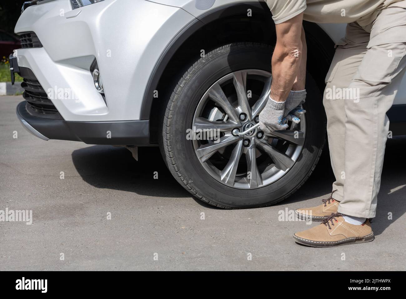 man tightening a bolt on a car wheel Stock Photo Alamy