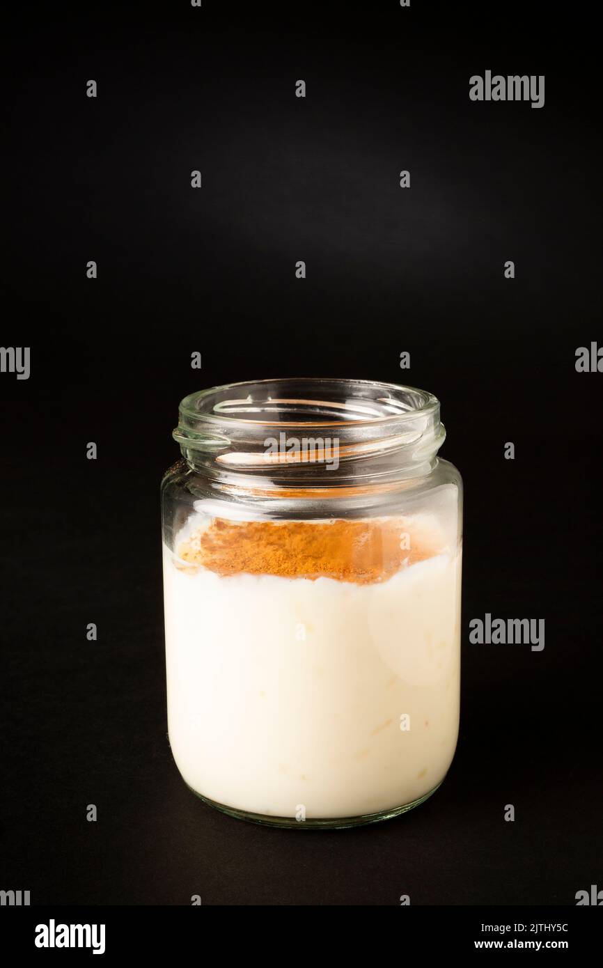 Homemade rice pudding in a glass pot over a black background Stock Photo