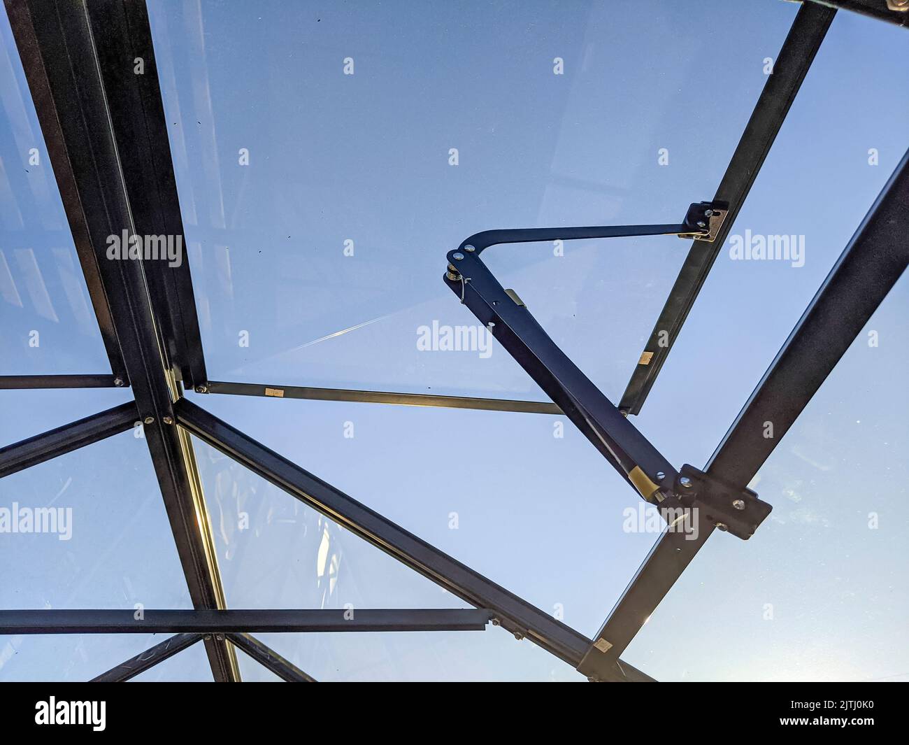 Automatic window vent opener on the roof of a greenhouse Stock Photo