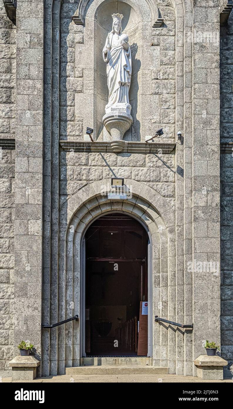 Entrance to a Roman Catholic church with a statue of Jesus above the door, Northern Ireland. Stock Photo