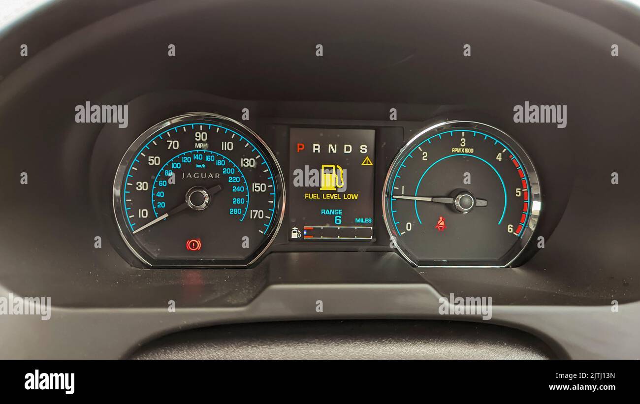 Dashboard of a Jaguar car showing very low fuel level with only 6 miles