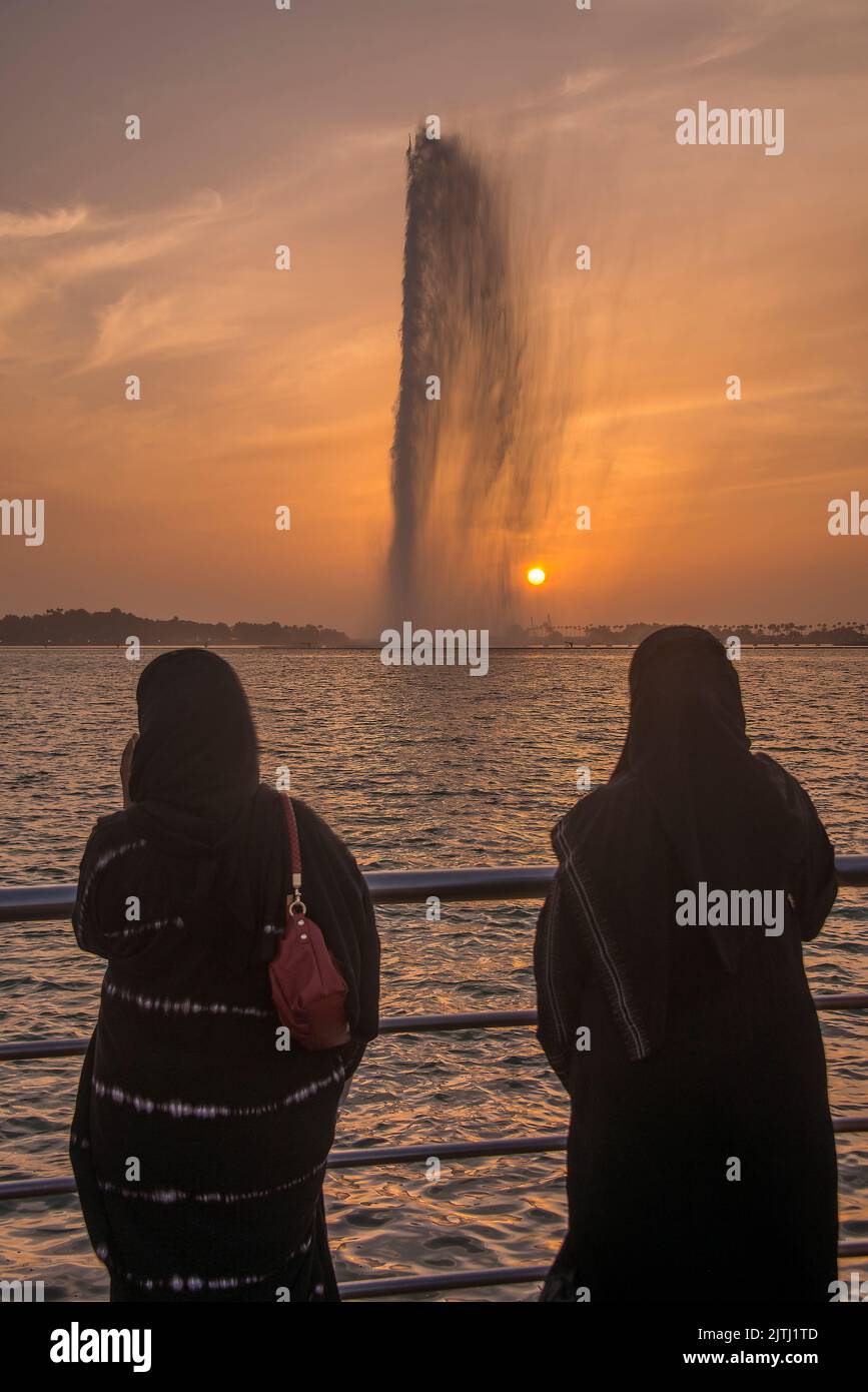 Two arab women observing King Fahd's Fountain at sunset Corniche Park Jeddah Saudi Arabia Stock Photo