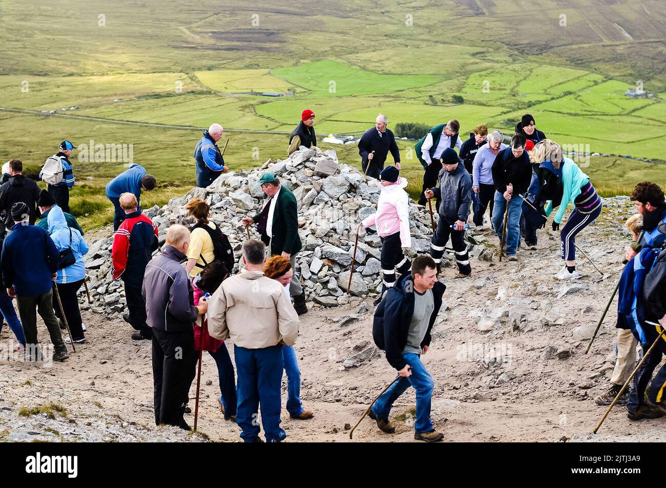 Pilgrims walk around a pile of rocks seven times, a traditional ritual during the Reek Sunday annual pilgramage, Croagh Patrick, County Mayo, Republic of Ireland. Stock Photo