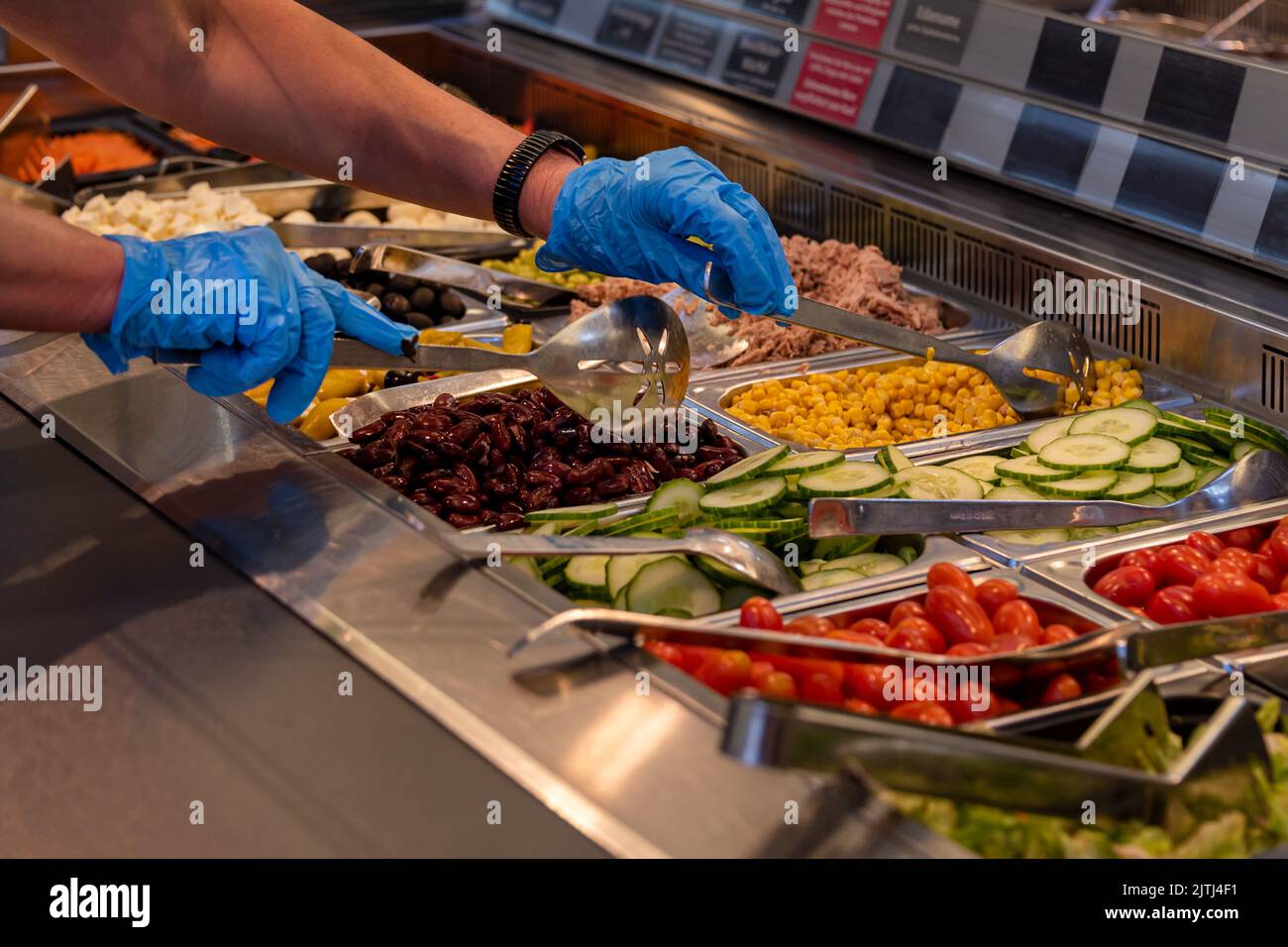 Choosing food from buffet. Fresh salad bar with a variety of fresh
