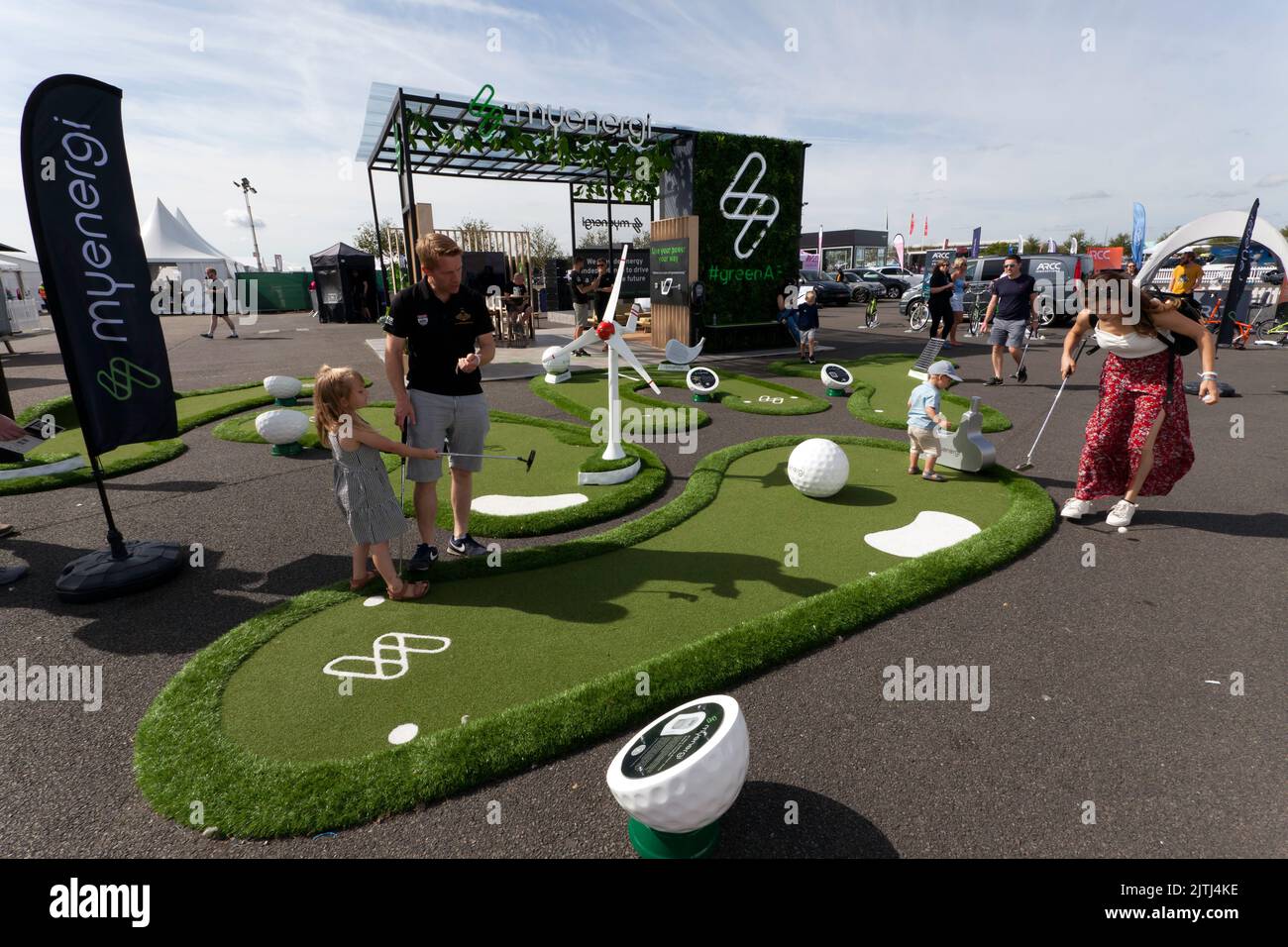A family playing crazy golf at the myenergi stand, during  the 2022 Silverstone Classic Stock Photo