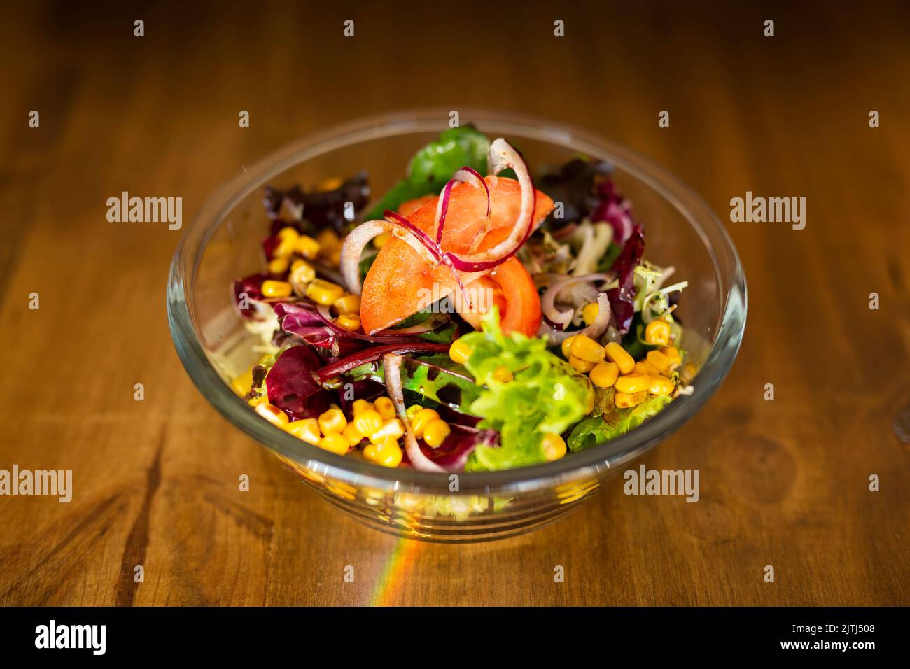 Green salad in a big bowl on a wooden table Stock Photo
