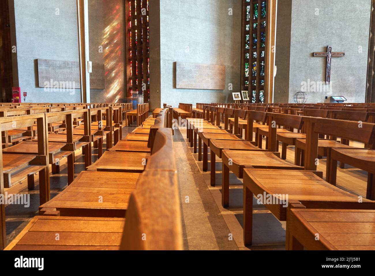 Empty wooden seats in Coventry cathedral, UK Stock Photo