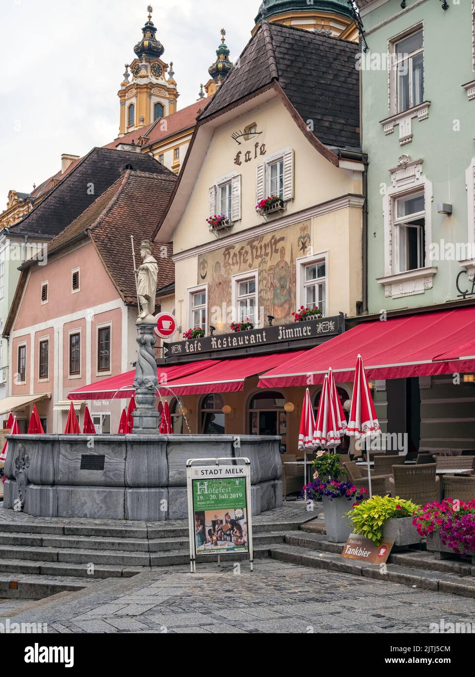 MELK, AUSTRIA - JULY 13, 2019:   Houses and restaurant in the old town with the Fountain of St. Koloman in the town square Stock Photo
