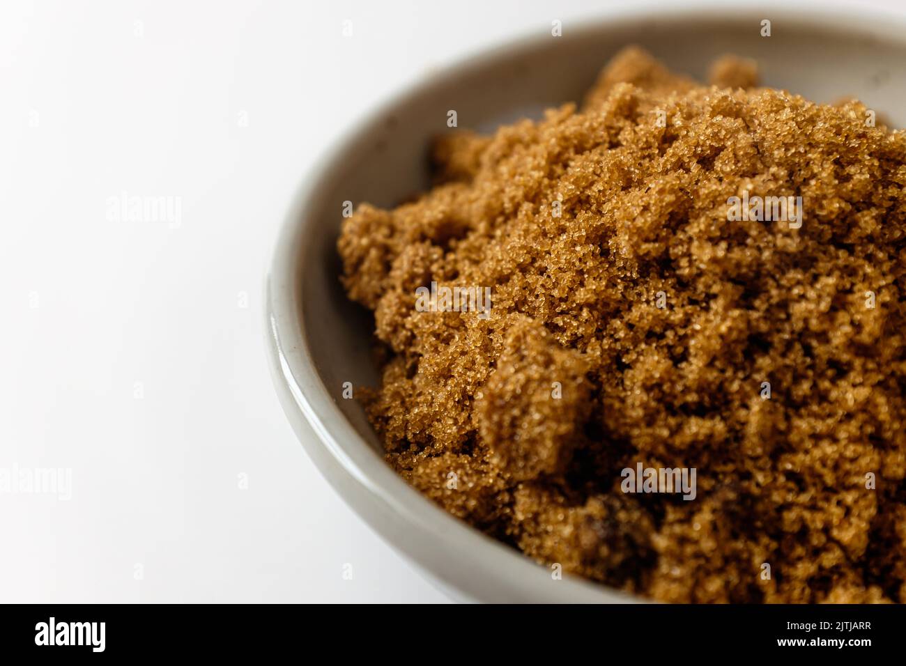 Dark brown sugar on a white background Stock Photo