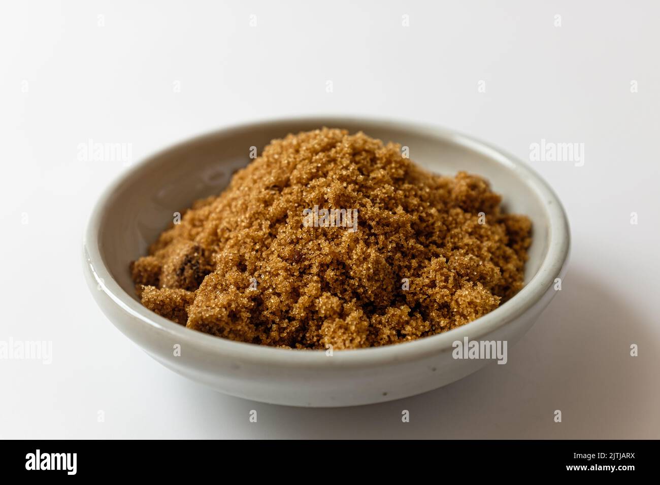 Dark brown sugar on a white background Stock Photo
