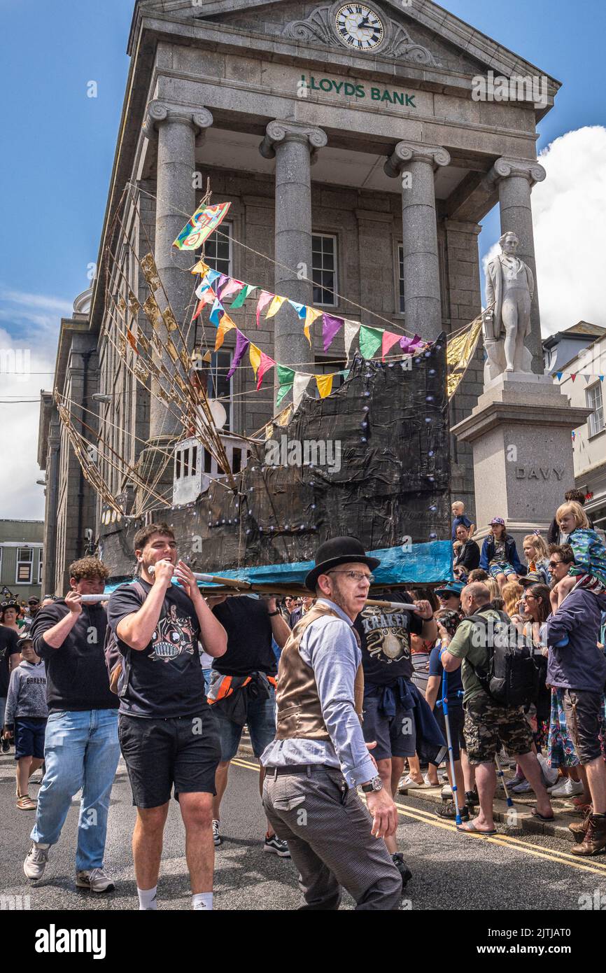 A large replica model of a fishing trawler made of withies and paper being carried in the Mazey Day parade celebrations as part of the Golowan Festiva Stock Photo