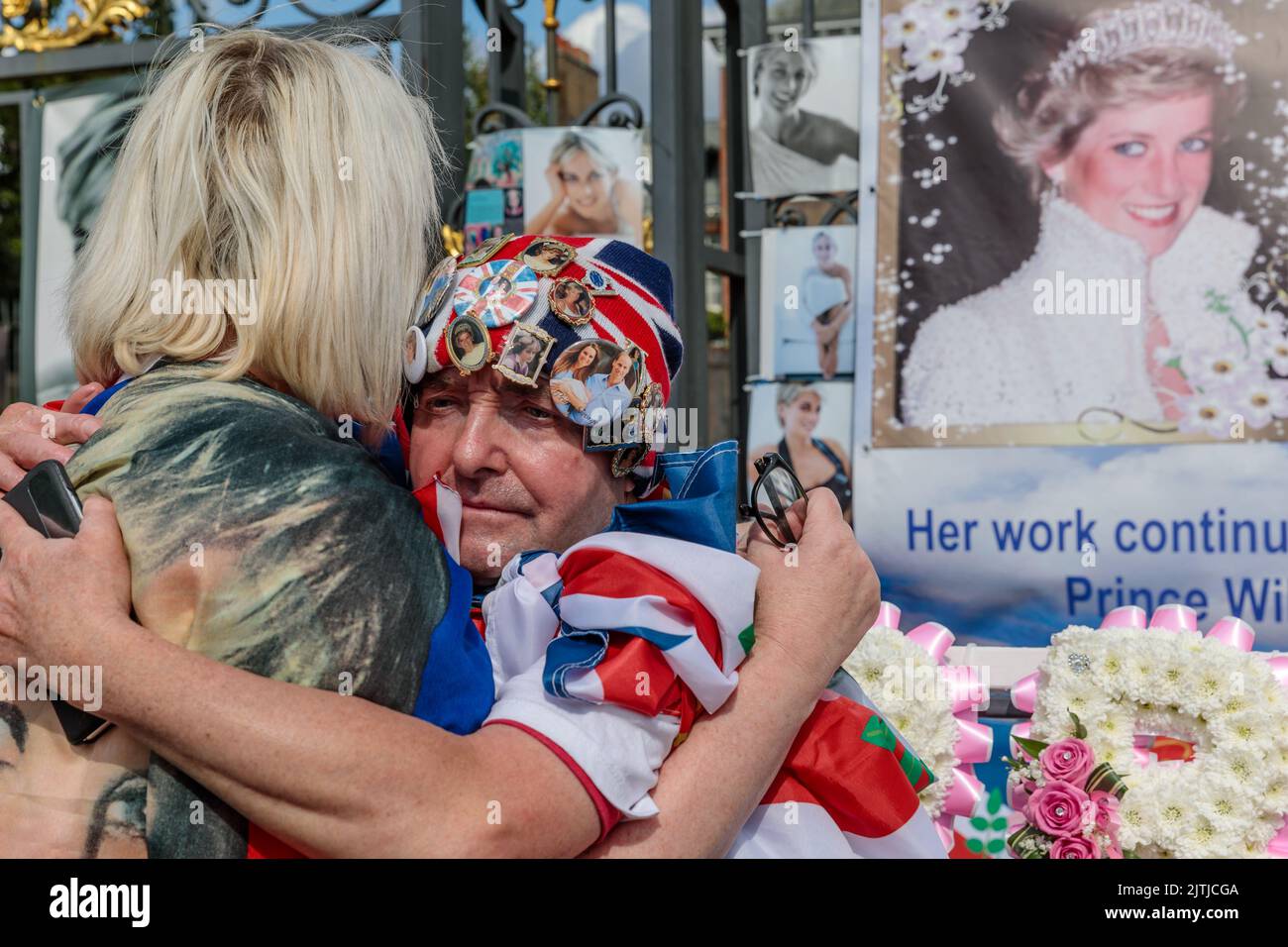 Kensington Palace, London, 31st August 2022.   Royal Fans Maria Scott and John Loughrey share a comforting hug at the Kensington Palace Gates on the 25th Anniversary of the death of Diana, Princess of Wales.  The Princess was killed in a car crash in Paris on this day in 1997.  Amanda Rose/Alamy Live News Stock Photo
