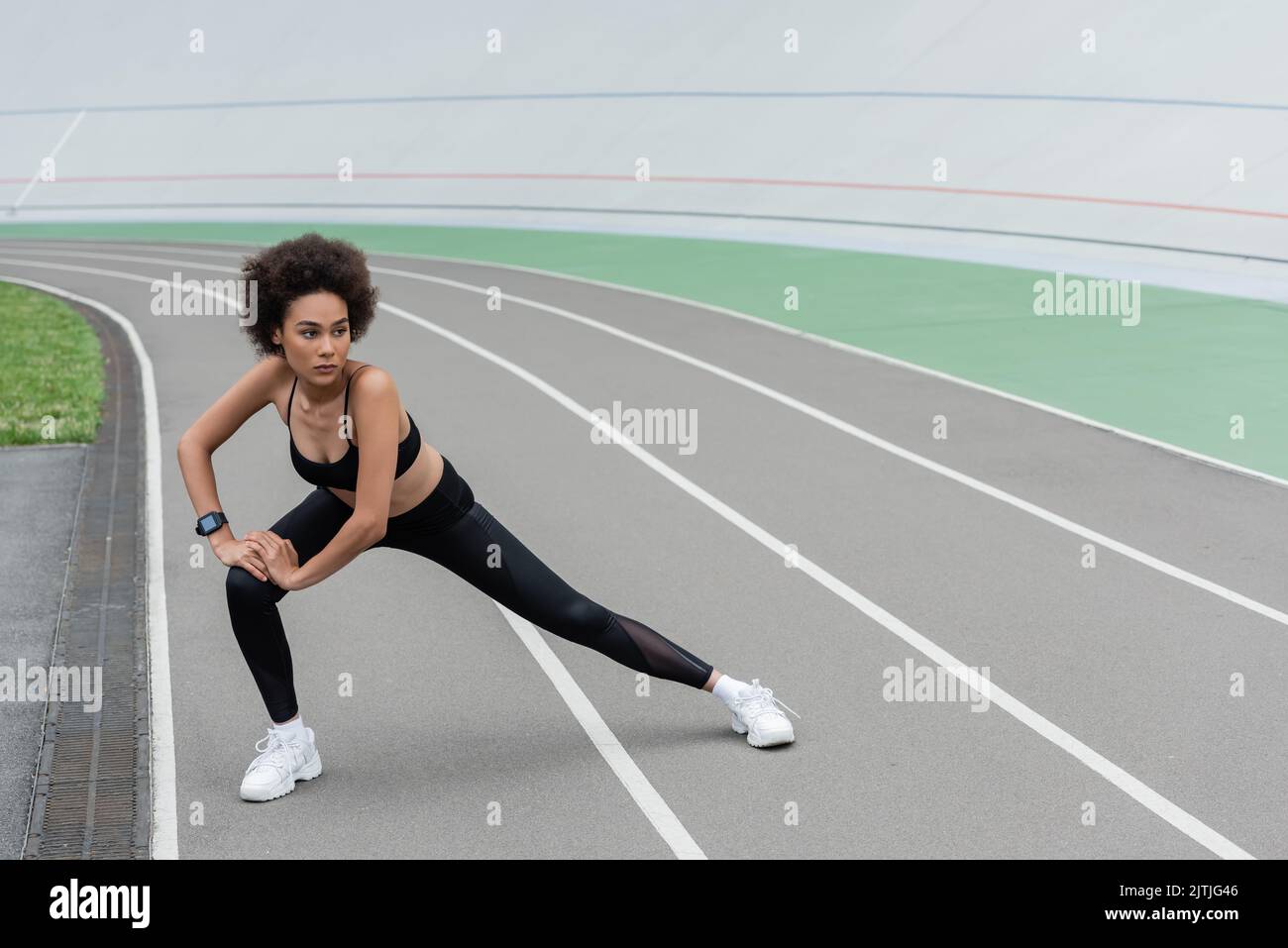 full length of african american woman in black sportswear doing side ...