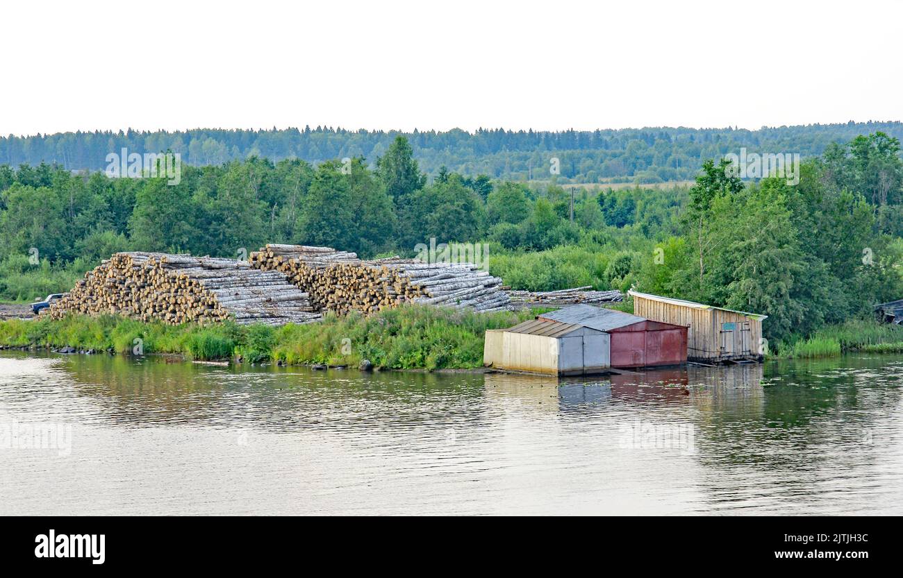 Stack of logs on the bank of the Svir river in Mandrogi, Russia, Russian Federation Stock Photo