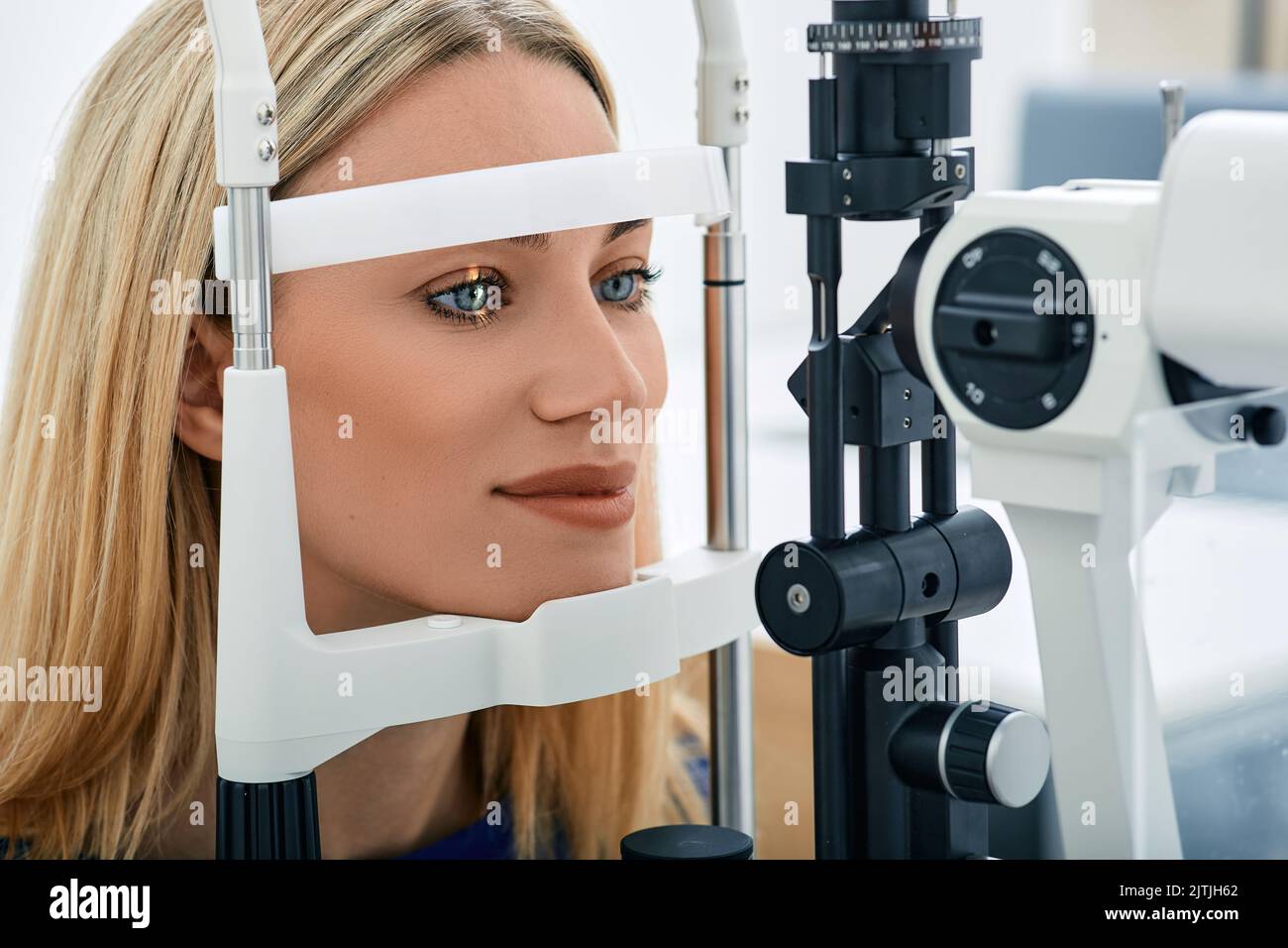 Beautiful blonde woman checkup her eyesight in ophthalmological clinic