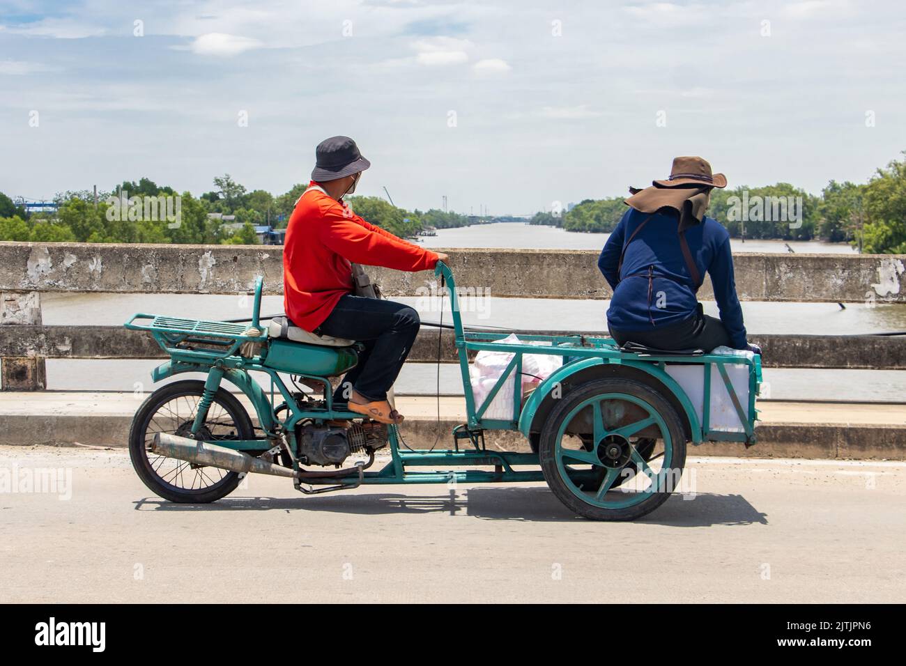 A two men rides a tricycle with a cart on a bridge Stock Photo Alamy