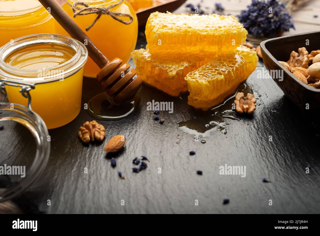 Honeycomb on slate tray with honey and nuts on kitchen table Stock Photo