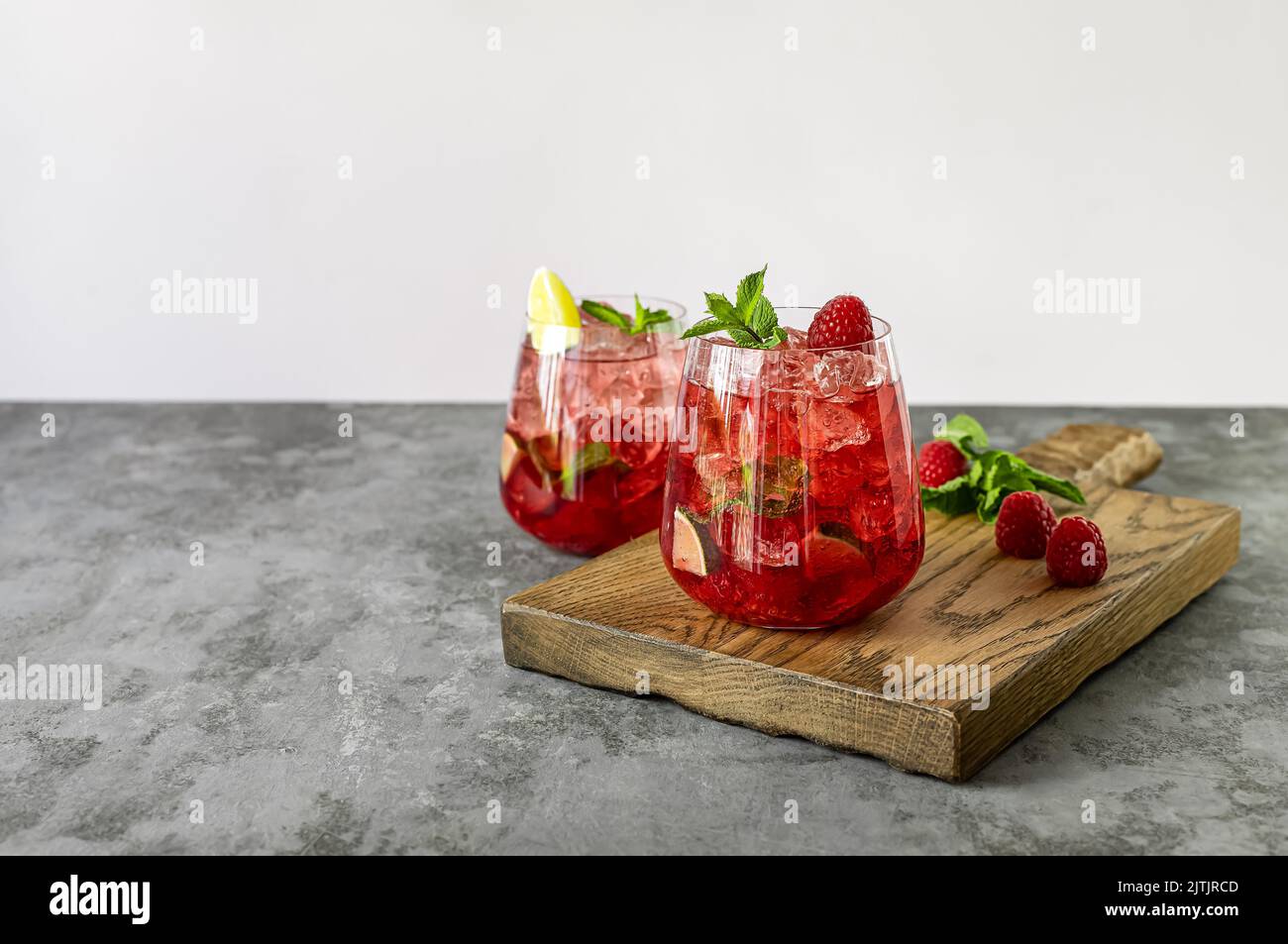 Bourbon or rum raspberry smash cocktail with lime and mint. Refreshing