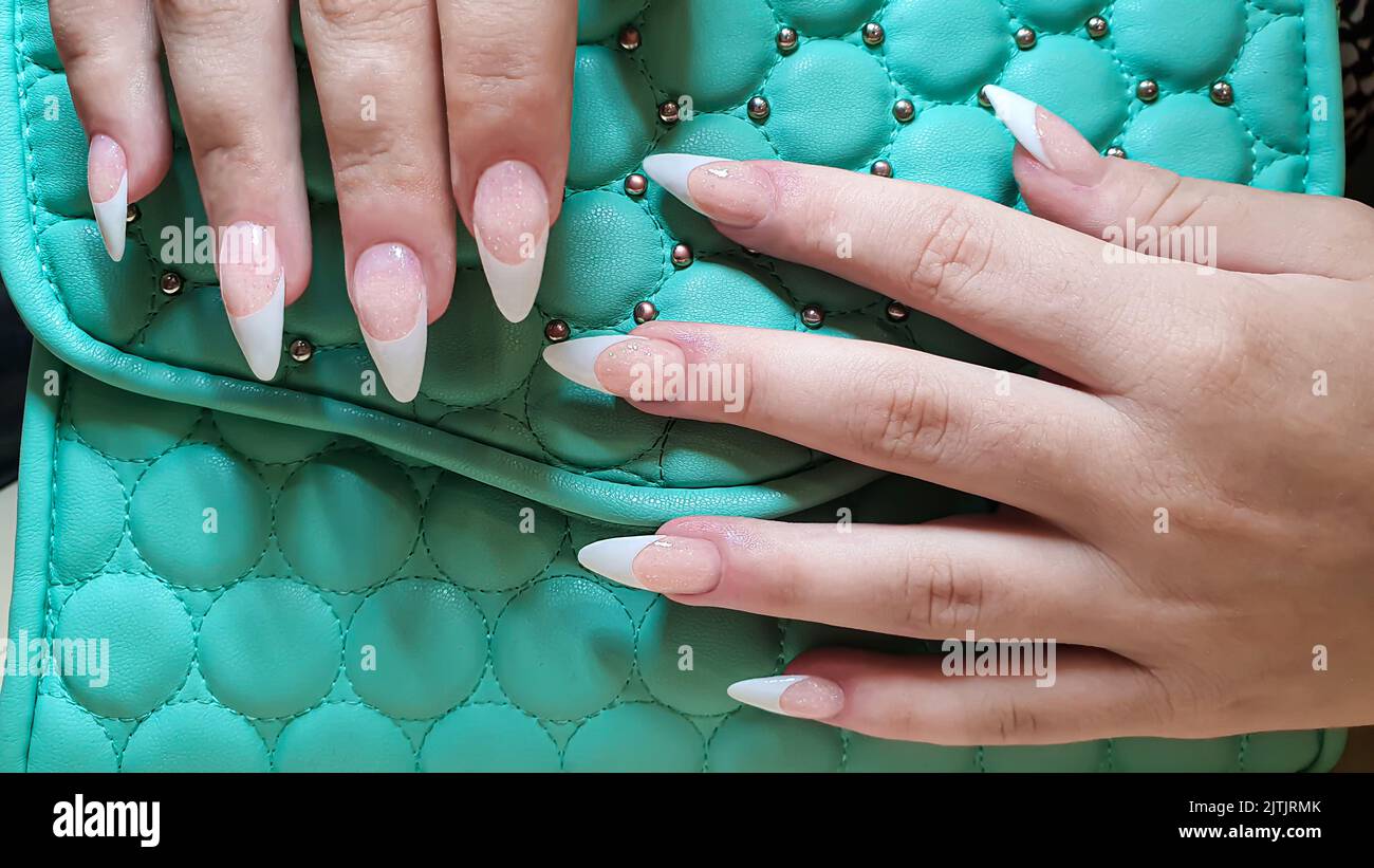 Acrylic nail extension, manicure, nail correction, hands in the