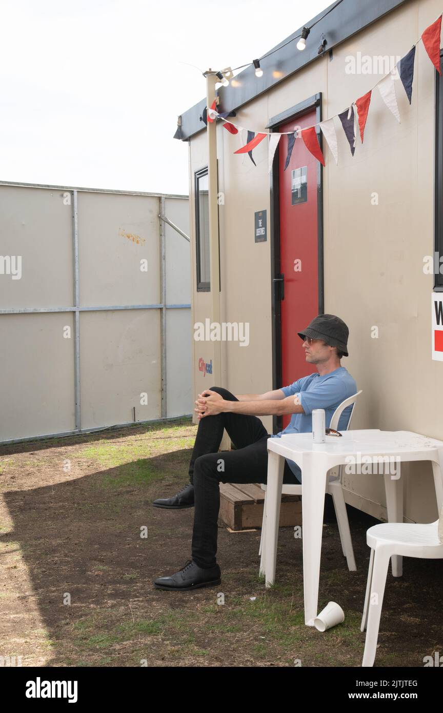 The Libertines bassist John Hassall chilling in the sun backstage at