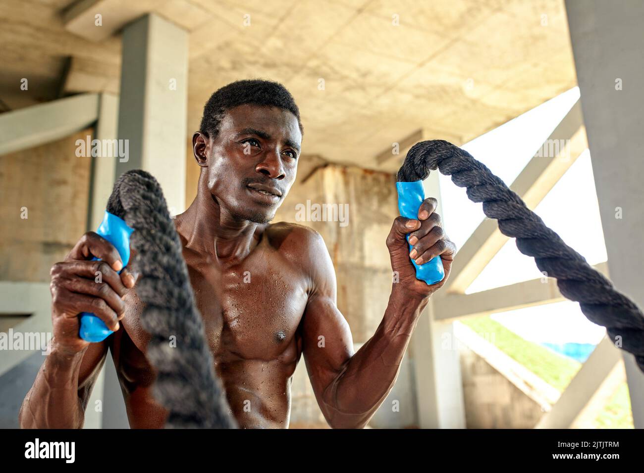 Rope workout. Sport man doing battle ropes exercise outdoor. Black male  athlete exercising, doing functional fitness training with heavy rope Stock  Photo - Alamy