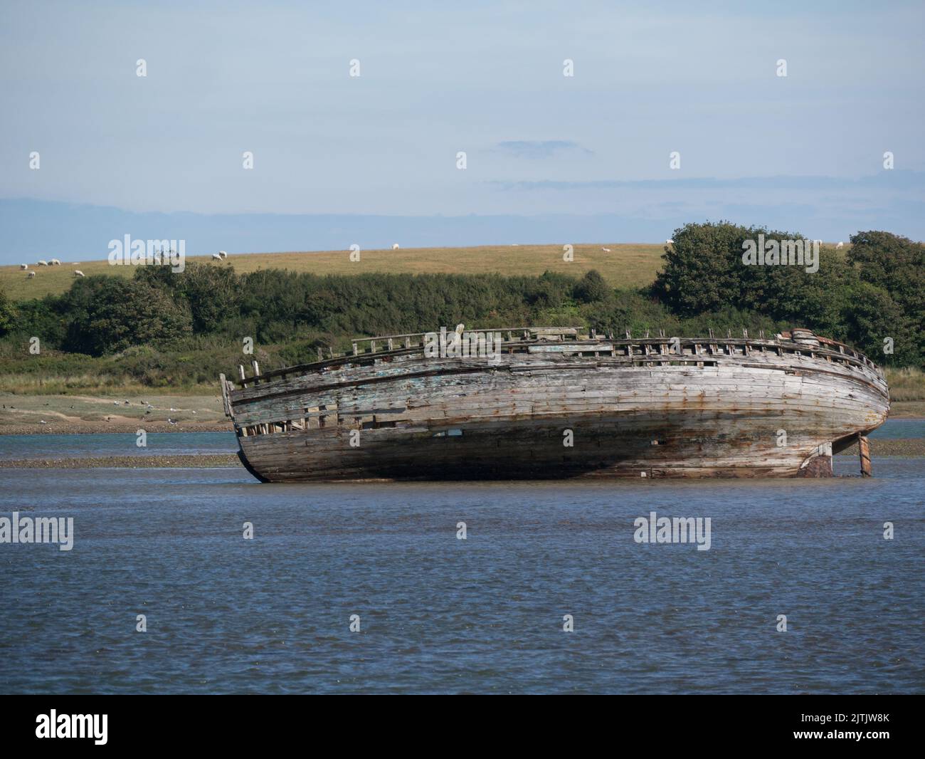 Abandoned wooden fishing boat on a sandbank in Traeth Dulas estuary Isle of Anglesey North Wales UK Stock Photo