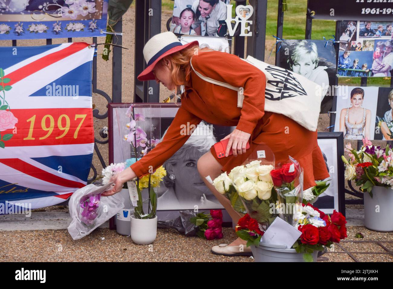 London, UK. 31st August 2022. A woman lays down flowers outside