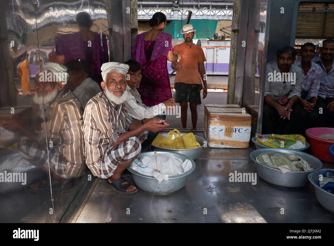 Porters sit in the goods compartment of a local train at Chhatrapati Shivaji Maharaj Terminus in Mumbai, India, out to make a delivery in the suburbs Stock Photo