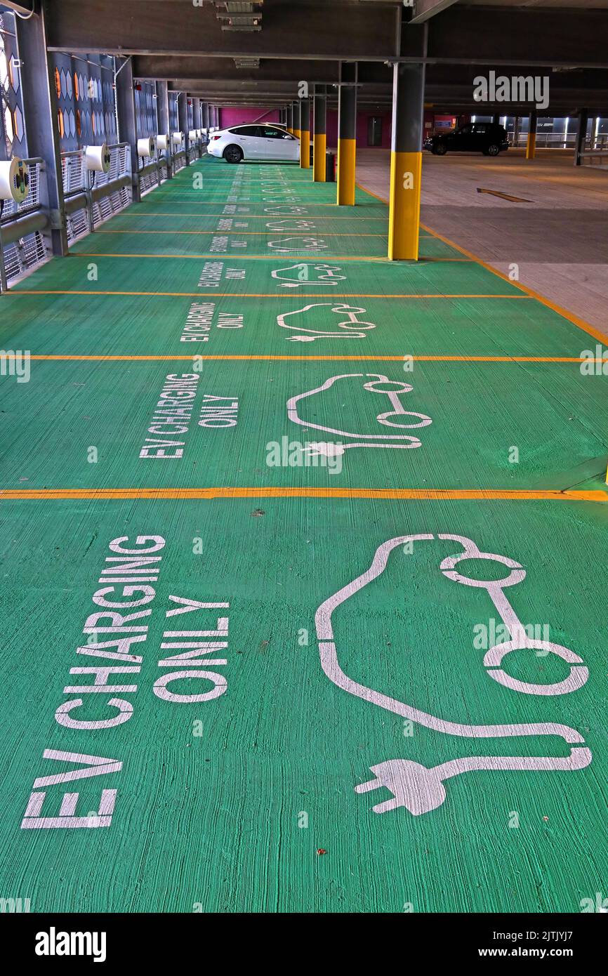 Green, EV Electric Vehicle, charging bays only, in Time Square multistory, car park, Warrington, Cheshire, England, UK, WA1 2NT Stock Photo