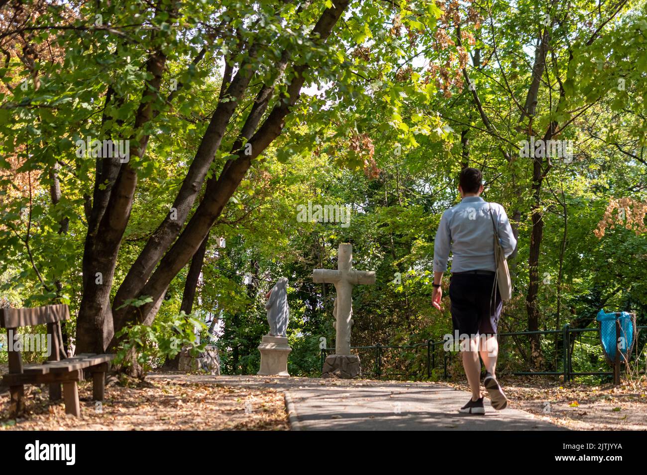 Walking european man in the park with a cross Stock Photo