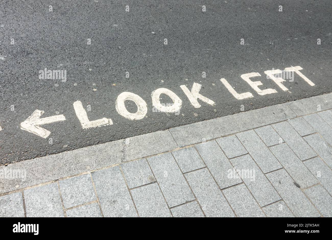 Look left, written at a pedestrian crossing in London, UK Stock Photo