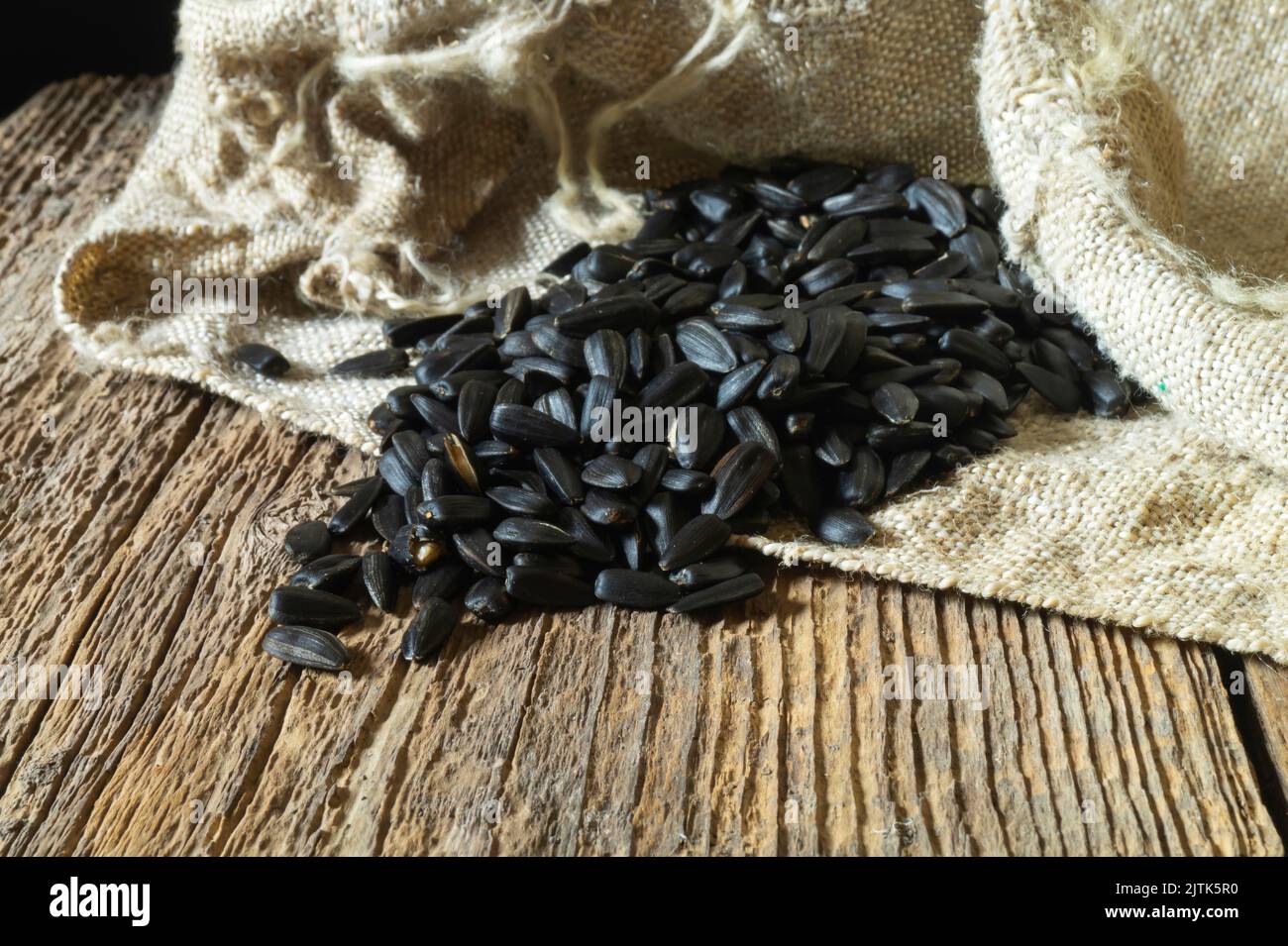 Still life with food on the background of burlap. A pile of seeds on an old board. Natural objects close-up Stock Photo