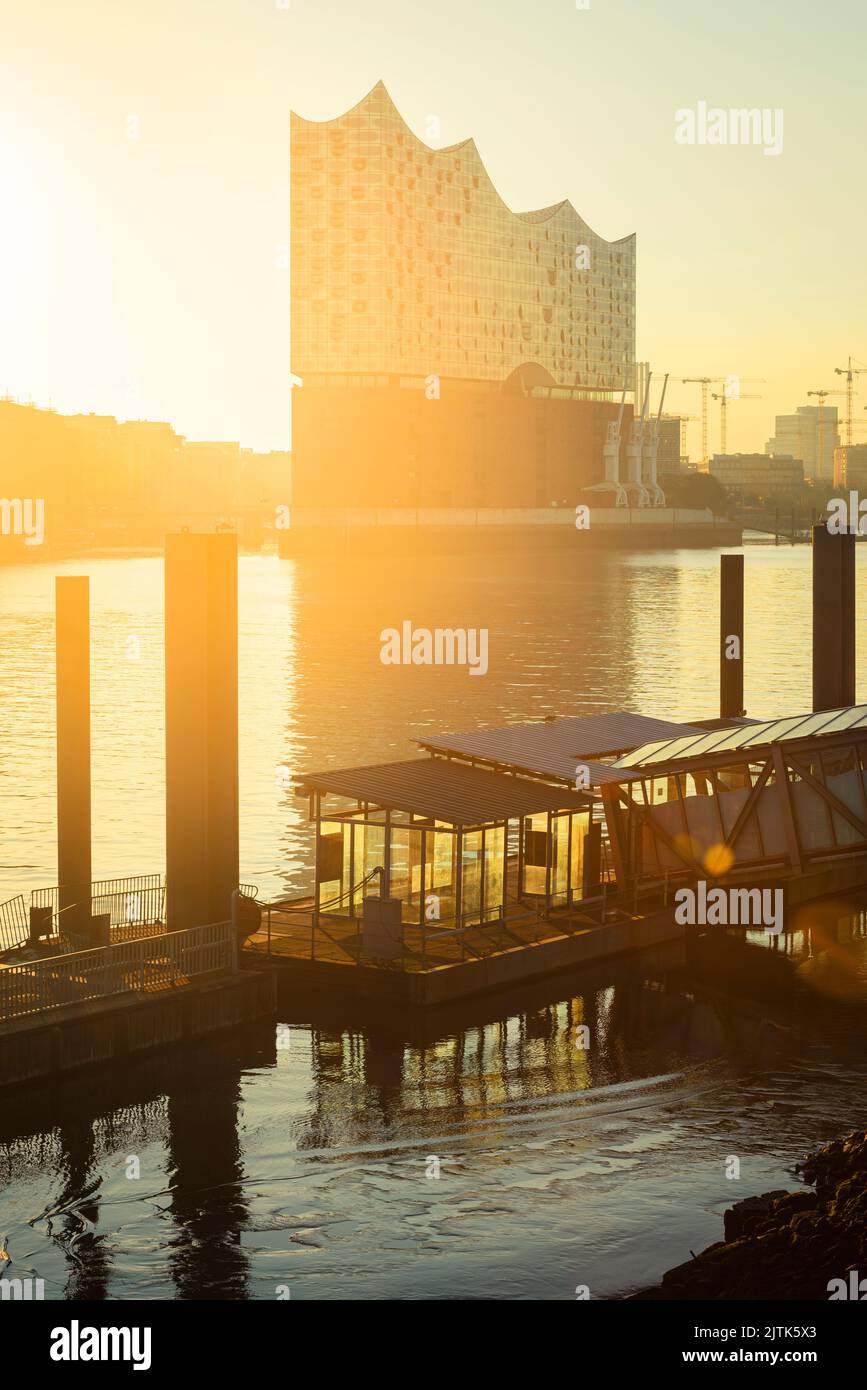 Sunrise at the Elbphilharmonie, Hafencity and a ferry pier in the river Elbe in Hamburg harbour, Germany Stock Photo