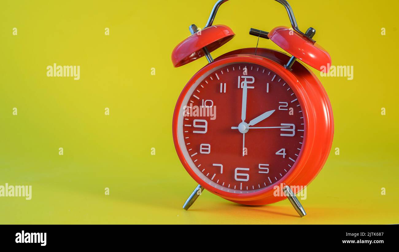 Red clock isolated on yellow background with copy space Stock Photo
