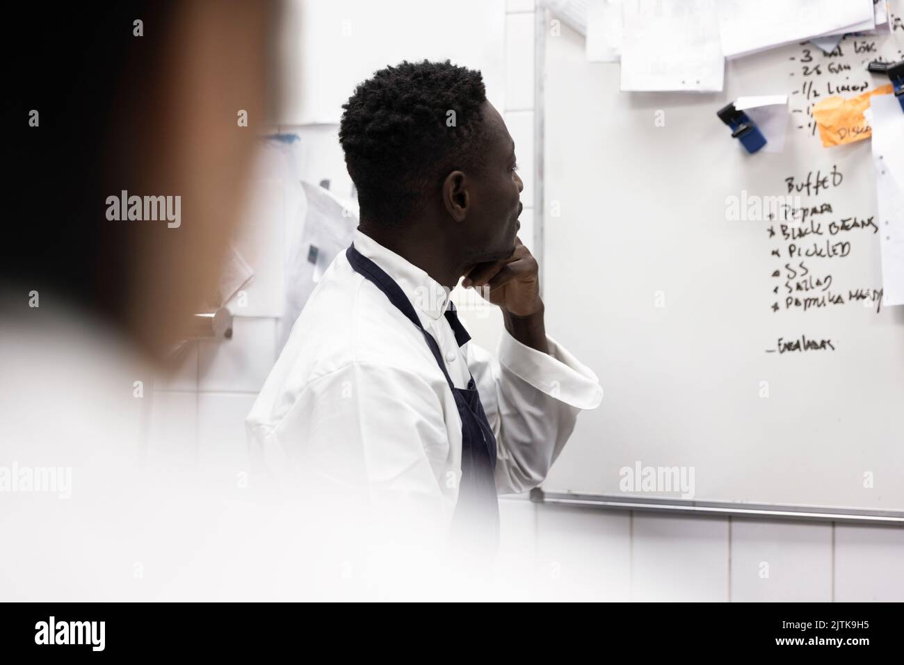 Chef reading menu on whiteboard in restaurant kitchen Stock Photo Alamy