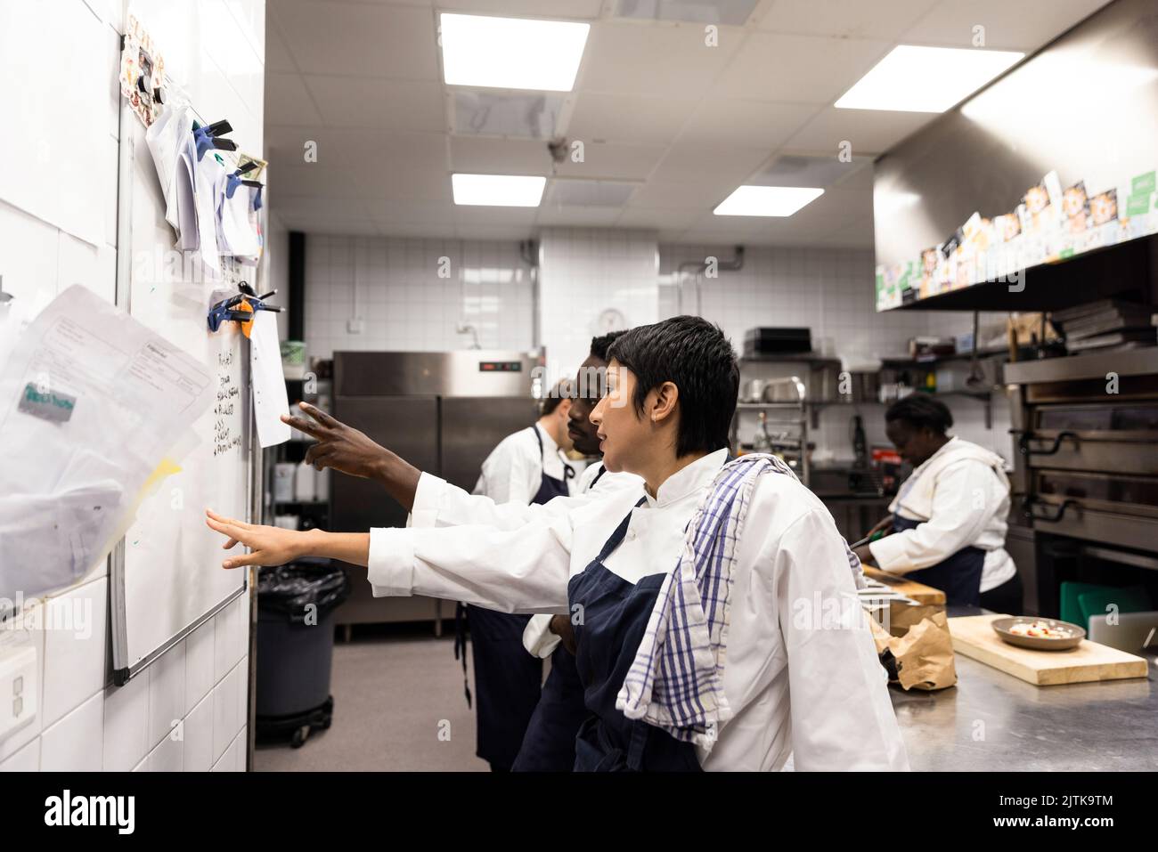 Small business owners planning while pointing at whiteboard in