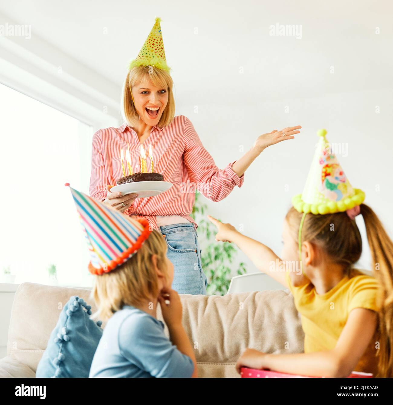 child family birthday celebration party cake father happy mother daughter son parent boy girl fun together candle holiday hat presen Stock Photo