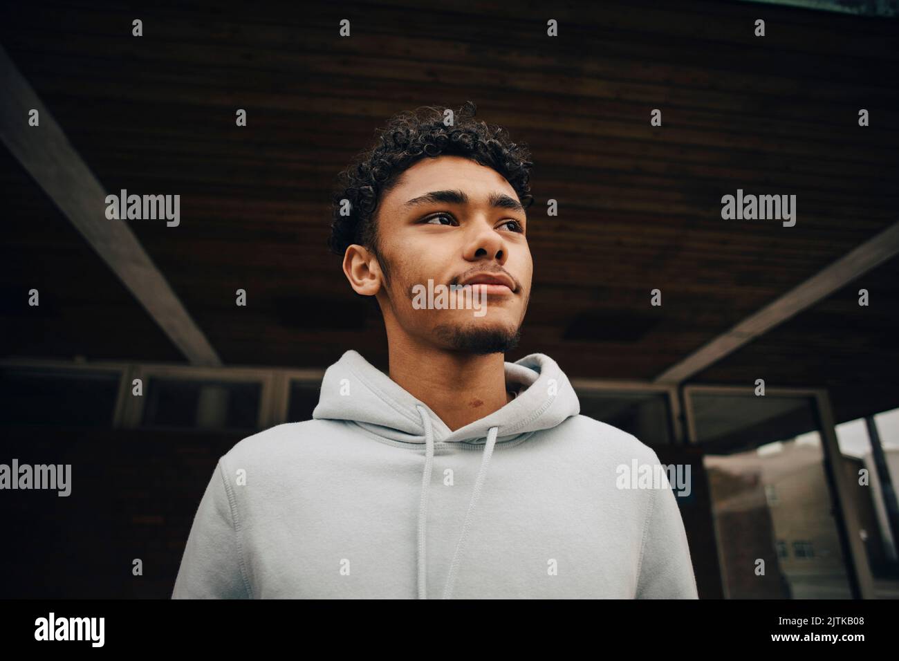 Young man looking away standing under bridge Stock Photo