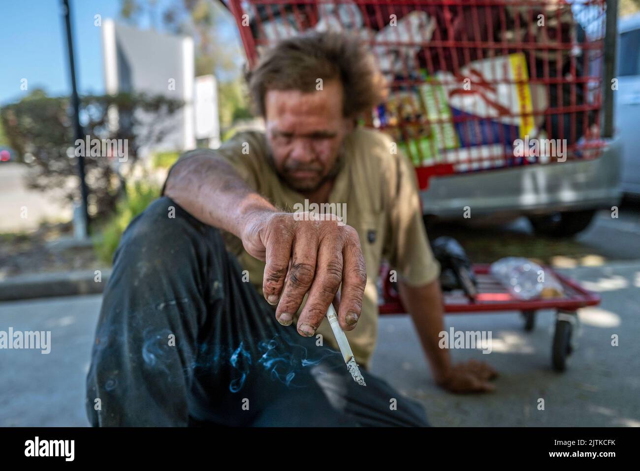 Vacaville, California, USA. 27th July, 2022. MARK RIPPEE, 59, who is blind, rests on the ground holding a cigarette in Vacaville. He said he needs someone to give him a ride to look for apartments and a job. (Credit Image: © Renee C. Byer/Sacramento Bee/ZUMA Press Wire) Stock Photo