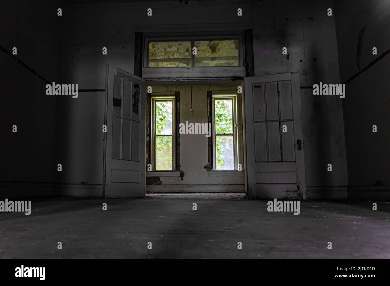 An abandoned empty room with destroyed walls and rusty windows with ...